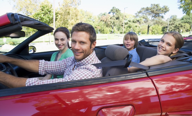 family of four in red convertible